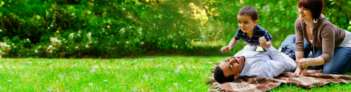 Young mixed race family playing in the park.